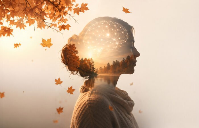 Woman in profile with autumn forest and glowing neural network overlaying her head, representing autumn blues and neurotransmitters